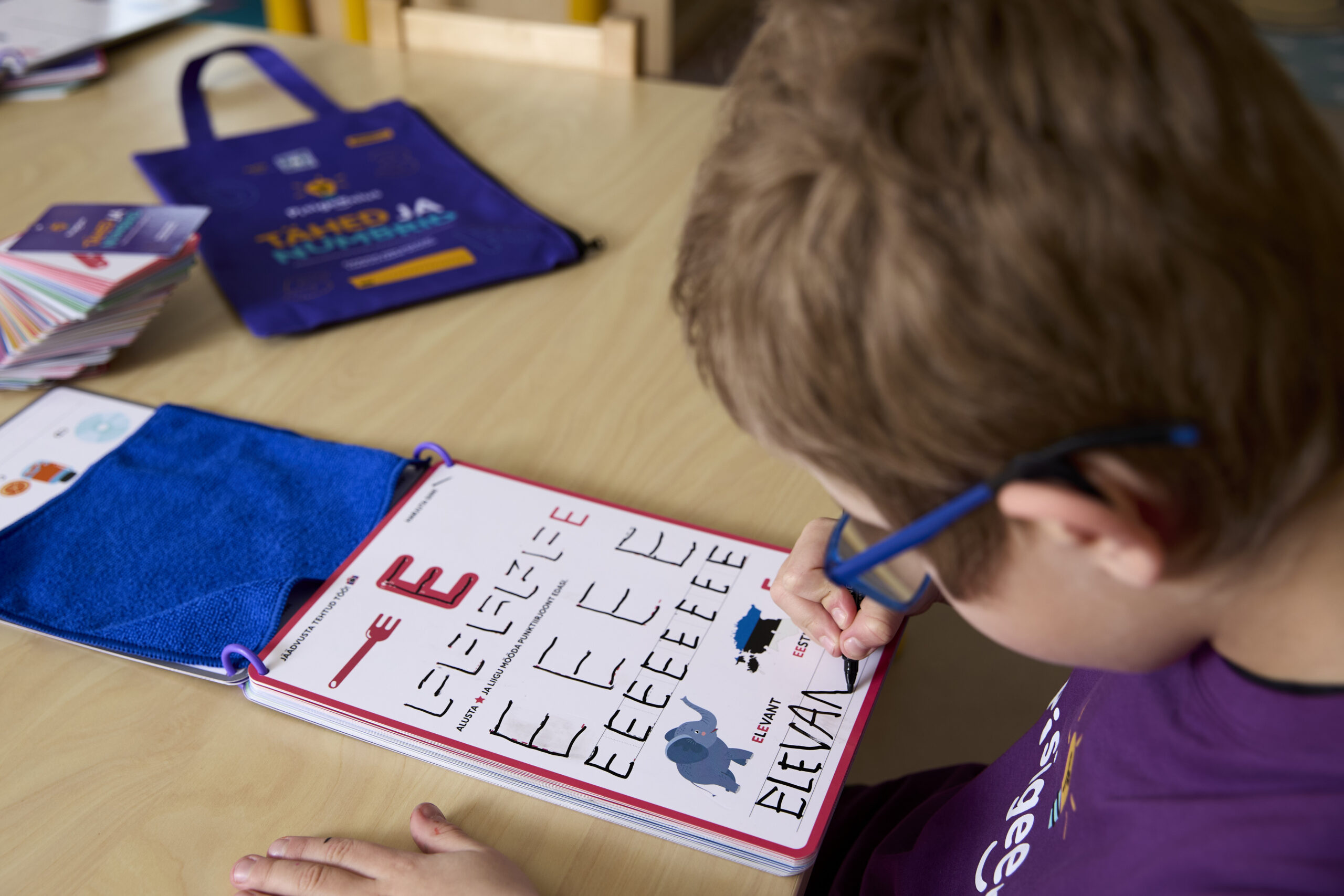 Poiss kirjutab Pisigeeniuse töölehele sõna "ELEVANT".